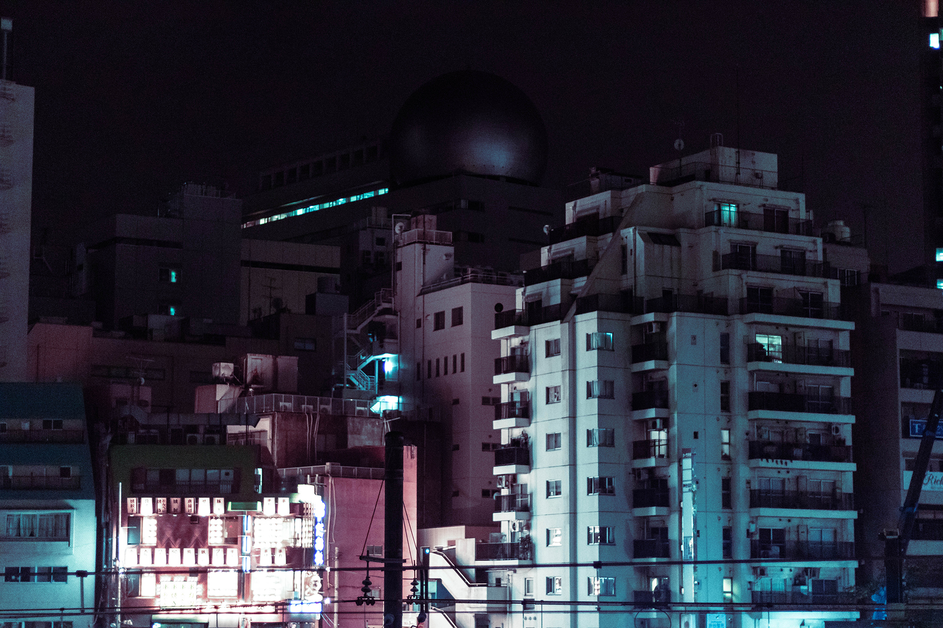 Multilevel complex of distant modern buildings lit from the street below.